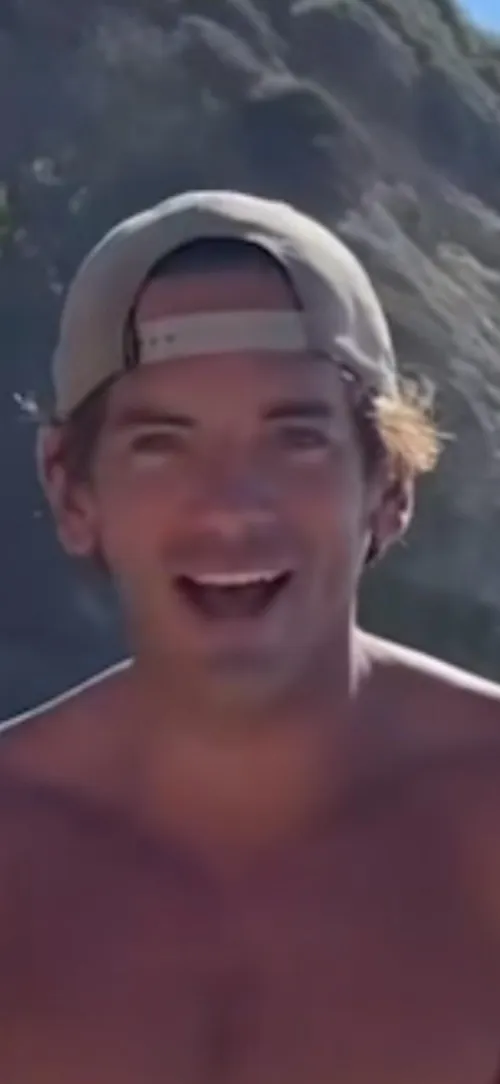 Man hitting golf balls into ocean