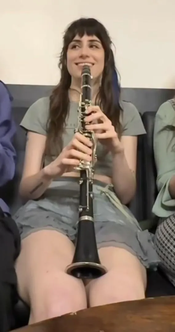 Dodie thighs while playing clarinet