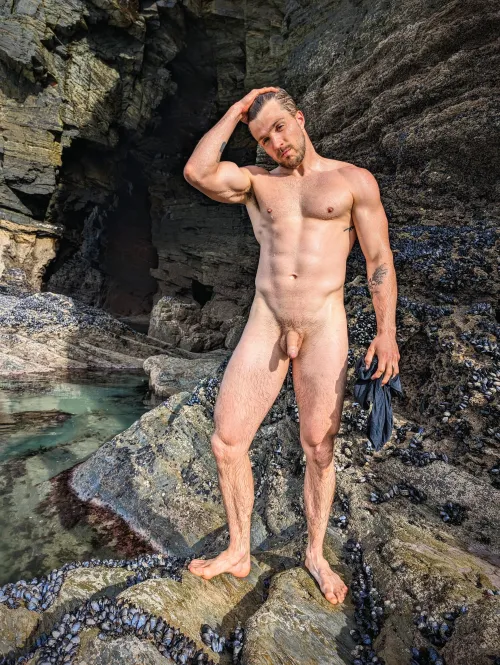 Strong muscular naked and soaking wet down by the ocean