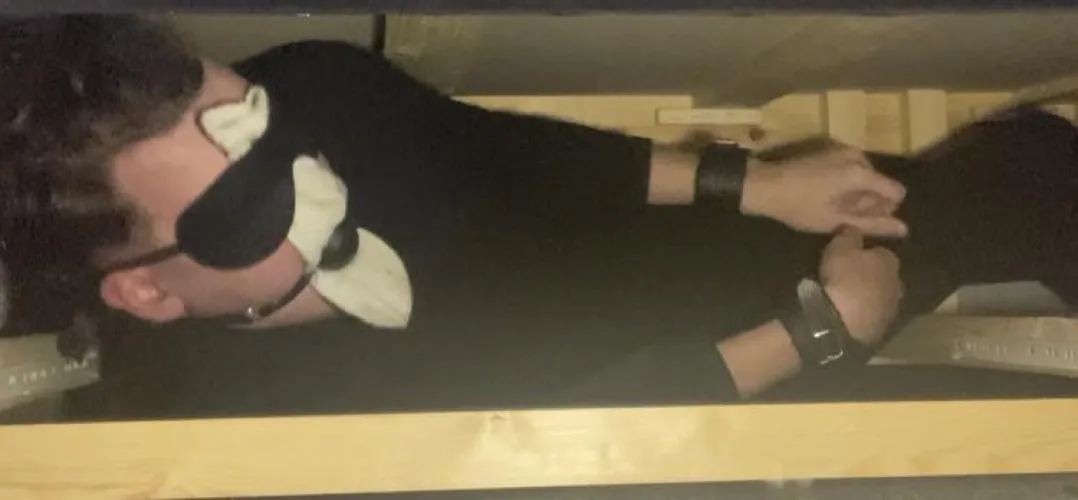 20 y/o male Stuffed in a dark wooden crate , mouth stuffed with socks held in by Ballgag , ankles and wrists cuffed , wearing tight black zip up jumpsuit , waiting to be sold at auction to spend my life as a bondage slave