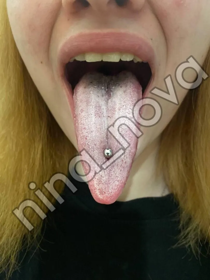 Redhead beauty with long wet pierced tongue
