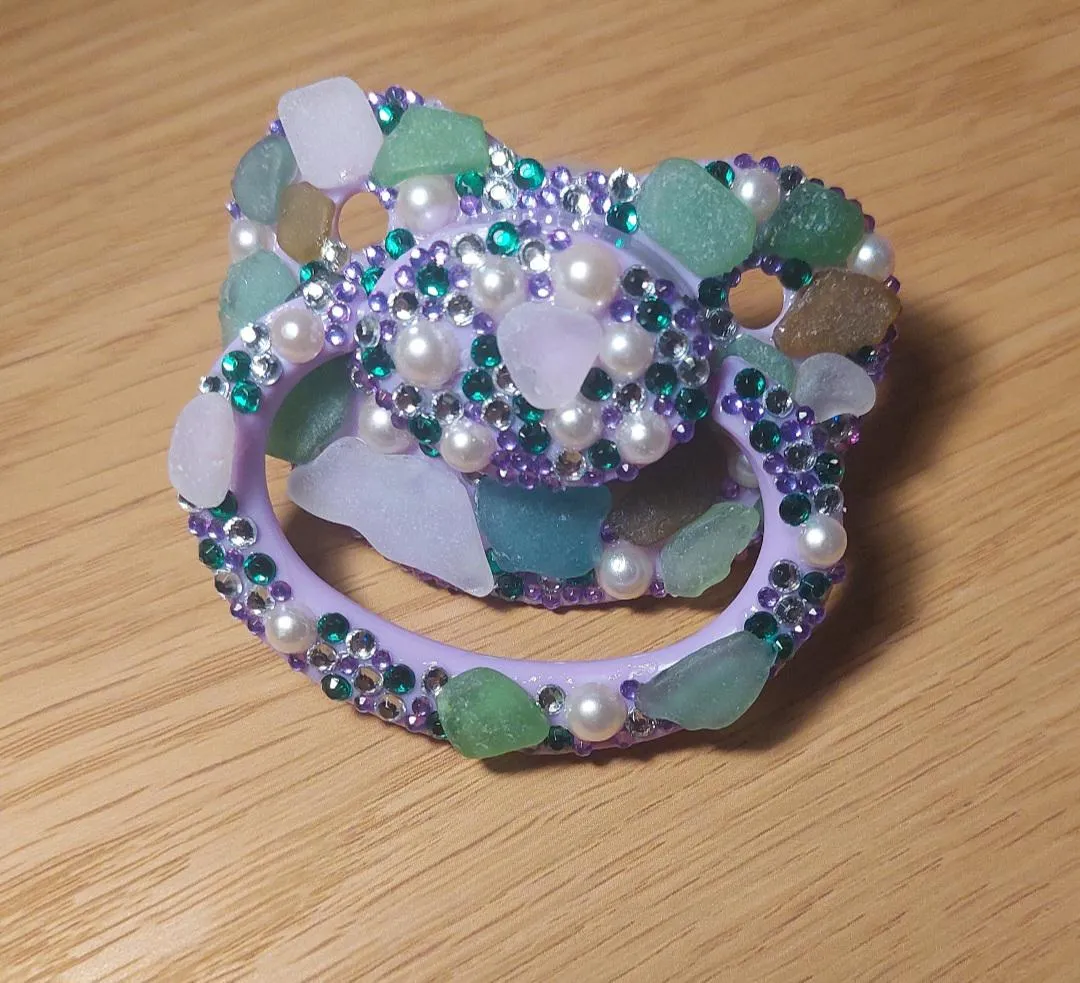 Decorated pacifyer with glass pieces and gems. Sea glass happens to be a special interest of mine besides bdsm