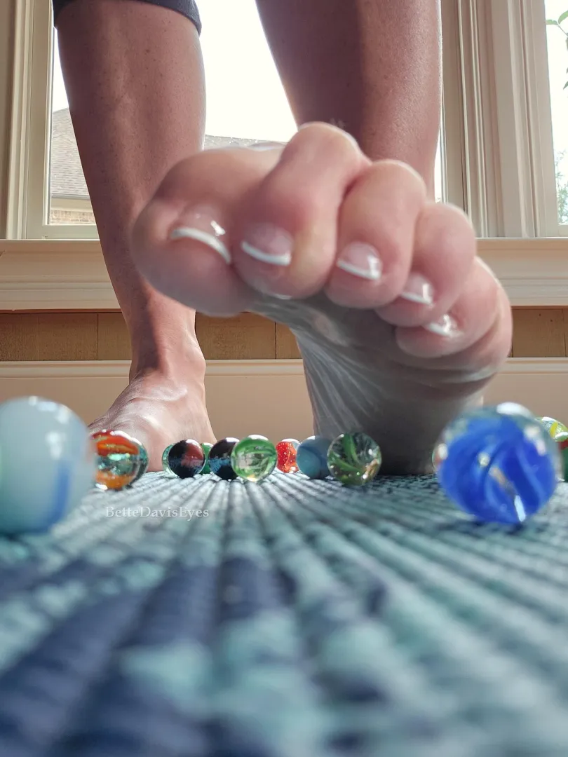 Toes tightening, releasing, selecting the next marble.